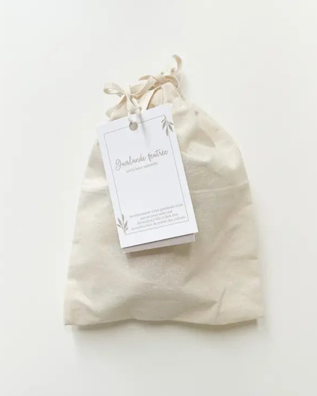 Pochon en coton bio fourni avec la guirlande de fleurs en laine feutrée.